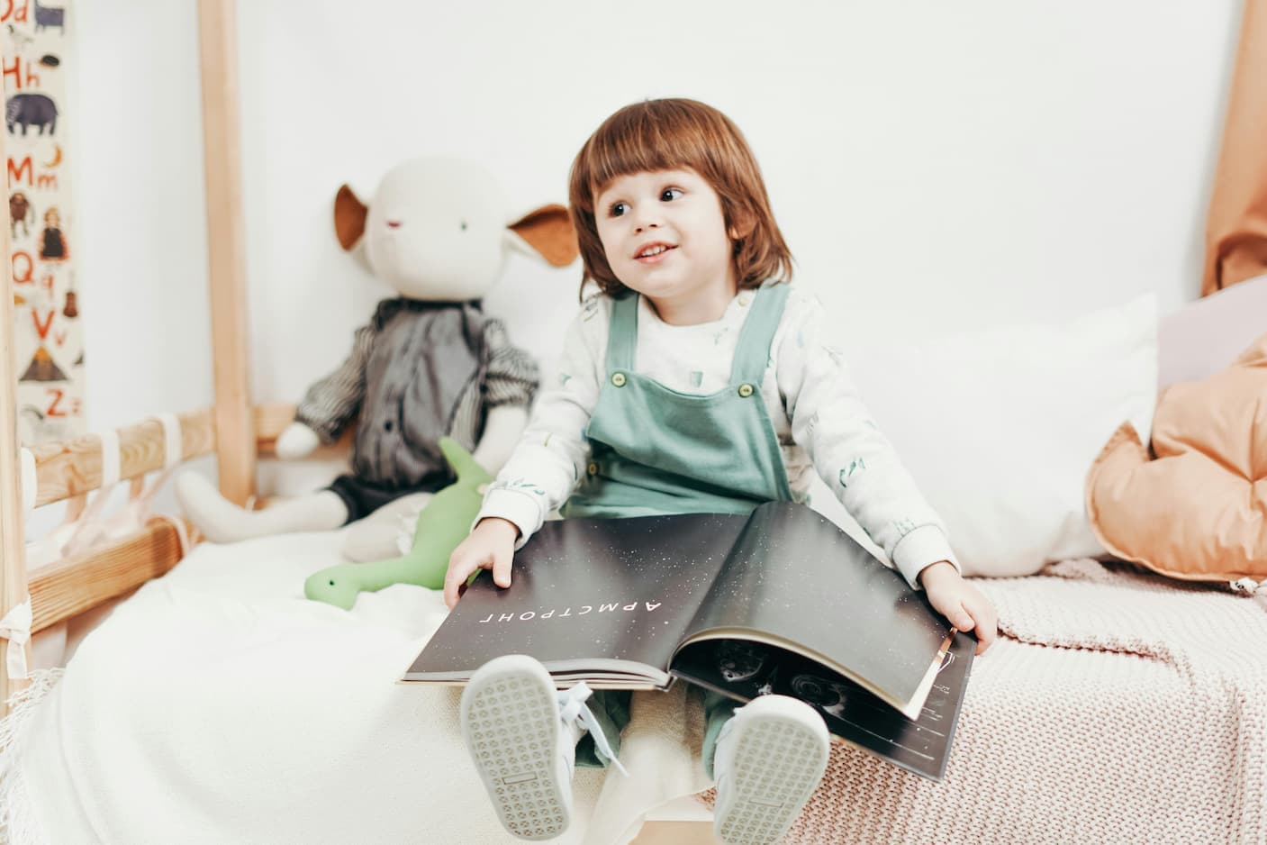 Kleinkind sitzt im Bett mit einem Bilderbuch – perfekte Kinderbücher ab 2 Jahren zum gemeinsamen Entdecken