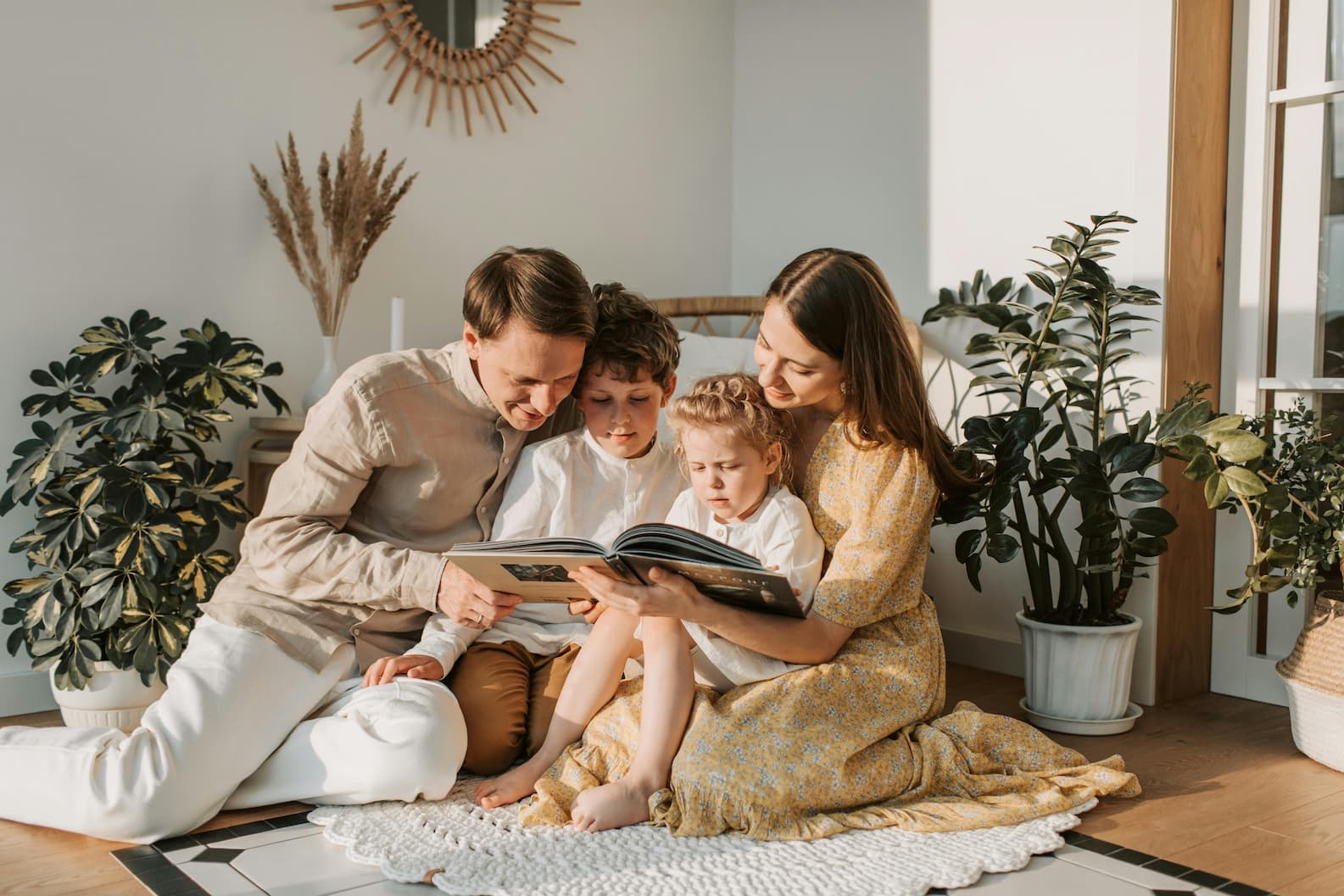 Familie sitzt gemeinsam auf dem Boden und liest – spannende Kinderbücher ab 4 Jahren mit Rätseln und Mitmach-Ideen